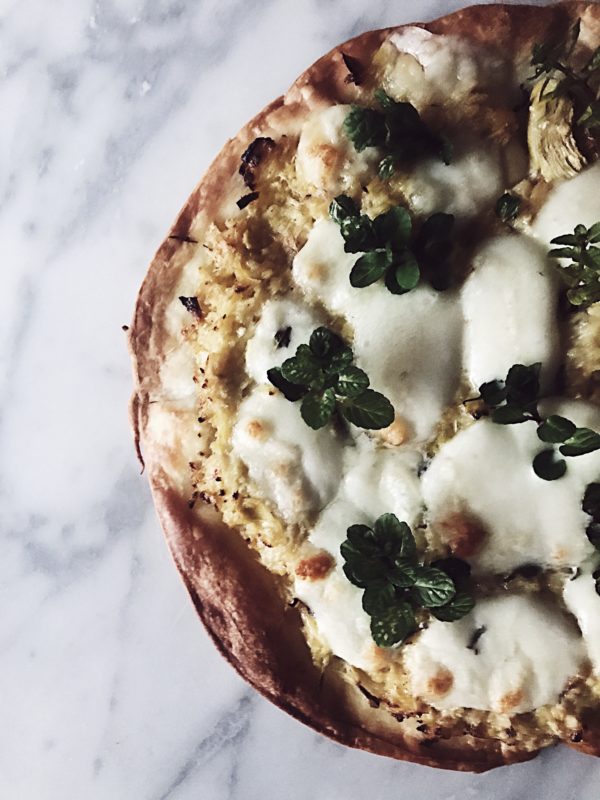 a cast iron skillet pizza recipe with artichokes cream, mint & mozzarella