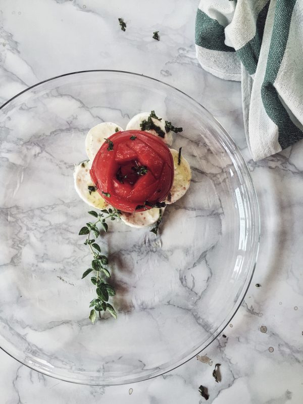 insalata caprese: una ricotta facile per le pigre notti estive, con olio aromatizzato all’origano e al basilica Imparato recentemente. UNO. Il cervello annebbiato è legato alla digestione. Avete presente quelle mattine in cui vi svegliate in stato confusionale: non riuscite a parlare bene, le parole non vengono alla mente, ecc? Se potete escludere i fumi dell’alcool, allora pensate a quello che avete mangiato a cena. Pizza con doppio formaggio e salame? A parole mie: una cattiva digestione provoca gonfiore; piccole bolle vanno su su, fino al cervello, durante la notte; il giorno dopo ci si sveglia un po' instupiditi. Niente di cui preoccuparsi, solo qualcosa interessante da sapere. DUE. La vera mozzarella non va in frigorifero: si dovrebbe tenere a temperatura ambiente, al massimo per due giorni. O almeno questo è quello che i foodie del sud Italia insegnano e fanno. Credetemi, ho visto gente dare via o buttare una deliziosa mozzarella, perché ormai con 1 giorno di vita. TRE. Il sale rosso hawaiano, oltre che bellissimo, ha 5 volte più ferro degli altri sali. Potrebbe servire allo stato confusionale del punto 1. Ora, lasciate che vi presenti il progetto Italian noshes (=spuntini). Ricette che coinvolgono poche-nessuna fonte di calore, dalla tradizione culinaria estiva italiana. Alcune autenticamente rispettose delle tradizioni, alcune con il mio tocco personale, altre con un po' più della mia consuetudine a “twistare”. Insalata caprese con olio caldo aromatizzato Ingredienti per 1 (duplicare secondo necessità): 1 pomodoro da insalata medio/piccolo 1 nodino di mozzarella o altro taglio 1 rametto di origano fresco 1 rametto di basilico sale rosso hawaiano 1 cucchiaio di olio d'oliva Sminuzza qualche foglia di basilico e tienile da parte per la guarnizione finale. Affetta o taglia a fiore (:-)) il pomodoro. Affetta la mozzarella. Mettili sul piatto di portata. Porta a ebollizione l'olio d'oliva, l’origano e il basilico rimasto. Versa l'olio aromatizzato sulla caprese. Cospargila di basilico e sale rosso. Servi subito.